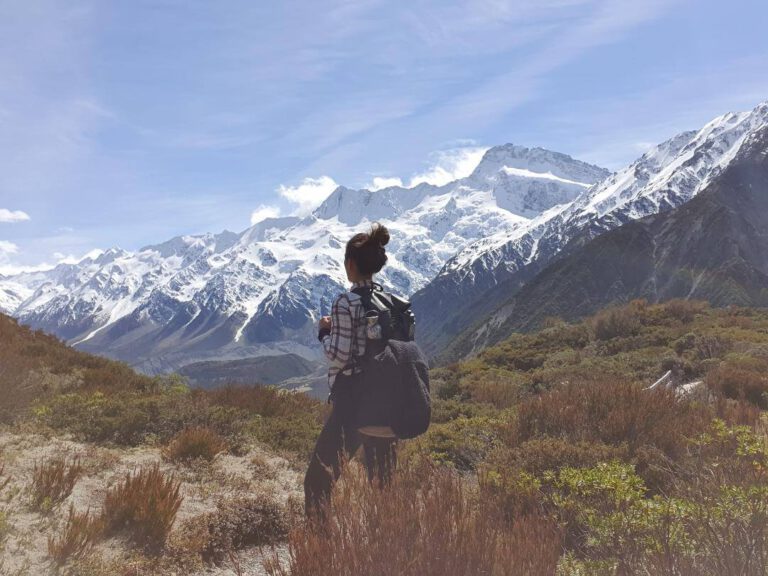 Frau wandert in den Schnee bedeckten Bergen