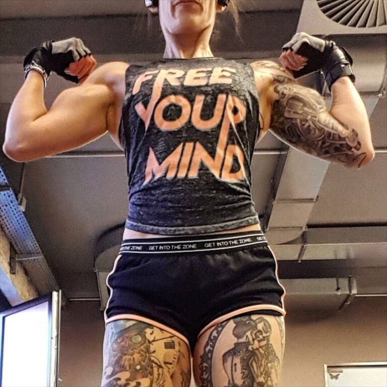 Tättowierte Frau spannt ihre Muskeln an