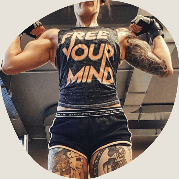 Frau mit Tattoos spannt die Armmuskeln an